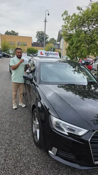 Learner holding their pass certificate beside a DriveSQ car with L-plate roof sign