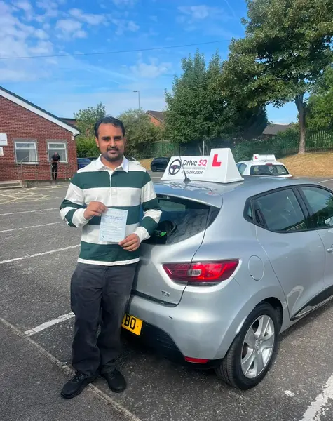 Learner celebrating their driving test pass next to a DriveSQ tuition car
